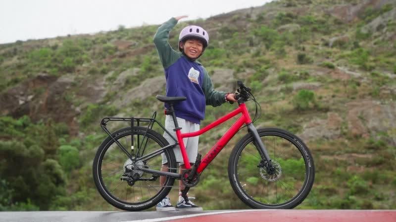 Kind neben einem roten woom-Fahrrad